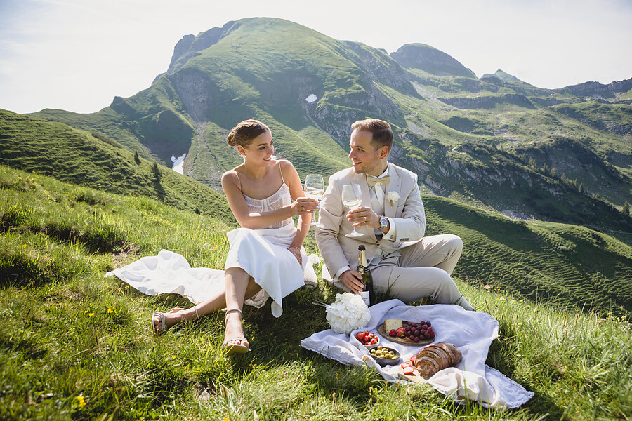 Brautpaar beim Picknick auf der Bergwiese