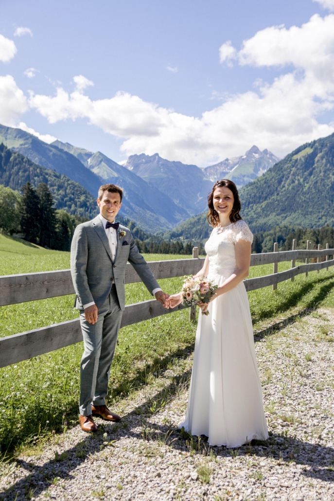 Brautpaar am Holzzaun mit Bergblick am Kühberg